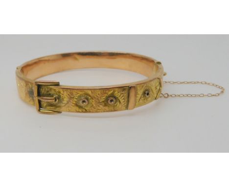 A 9ct gold fern engraved hollow buckle design bangle, hallmarked Birmingham 1905, inner diameter 6cm, width 1cm, weight 11.2g