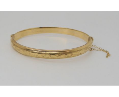 A 9ct gold engraved hollow bangle, inner diameter 6cm, width 6.3mm, weight 8.3gms Condition Report:Available upon request