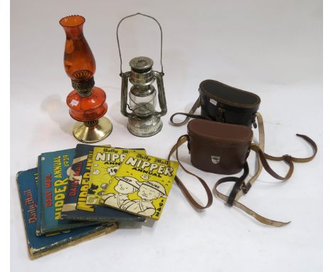 Two cased pairs of binoculars, a collection of 1030s/40s Daily Mail Nipper annuals, a coloured glass oil lamp and a storm lan