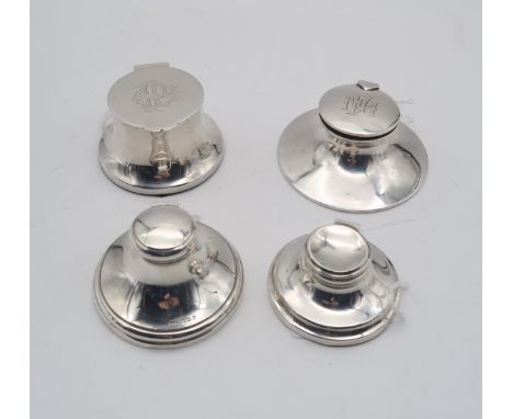 A collection of four silver inkwells, all of circular form, one Edwardian example by Hamilton &amp; Inches with clear glass l