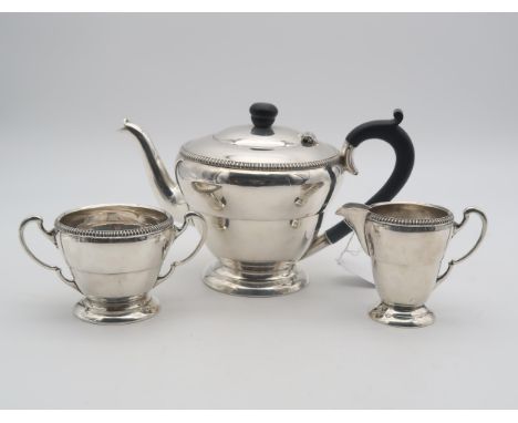 A George VI silver bachelors tea service, of flared form, the body with banding, with gadrooned rims, on stepped circular bas