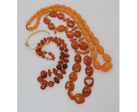 Two amber coloured bead necklaces, from left to right in the photo, freeform beads largest approx 22mm x 18mm, weight 41.1gms