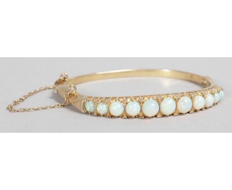 A GOOD YELLOW GOLD AND OPAL BRACELET set with eleven opals.