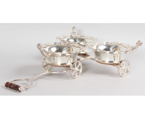 A SILVER PLATE TRIPLE TABLE WINE COASTER TROLLEY, with turned wood bases and pierced wheels.