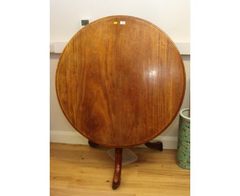 A 19th Century mahogany circular tilt top dining table, stamped with broad arrow and dated 1935, on tripod base, 41" dia