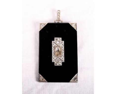 An Art Deco onyx and white metal pendant centrally mounted seven old cut diamonds with further diamonds to the white metal co