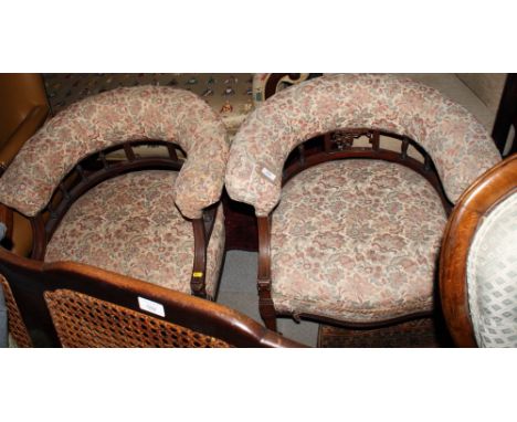 A pair of Victorian low back armchairs with upholstered half round back rails on spindle galleries, upholstered in a floral t