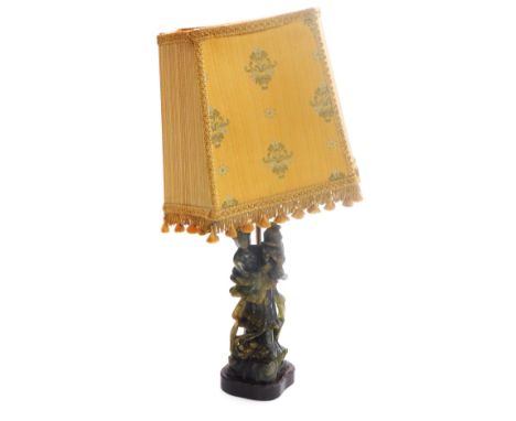 An early 20thC Chinese soapstone figural table lamp, modelled as a lady holding a cage, with a trailing garland of flowers, o