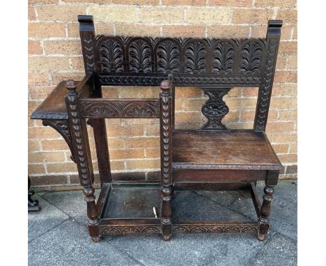 A CARVED OAK HALL BENCH/STICK STAND  105cm wide 101cm high