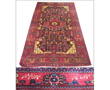 SIGNED HAMADAN CARPET, 260cm x 155cm, central medallion on a noir field of stylised botanical motifs within corresponding spa