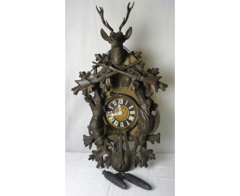 A 19th century German Black Forest mantel clock: 
The dial with Roman chapter ring flanked by pendants of dead game, the cres