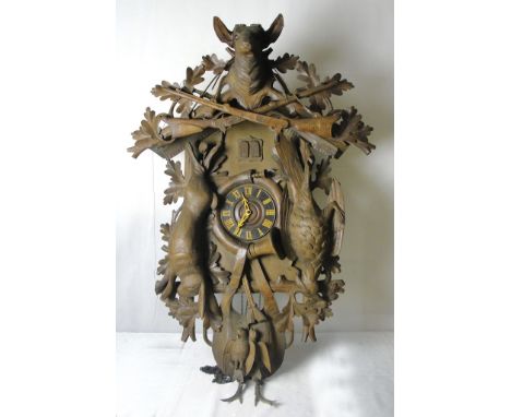 A late 19th century German black forest wall hanging cuckoo clock: 
The dial with Roman chapter ring flanked by pendants of d