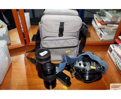 A Praktica MTL3 camera together with a camera lens etc.