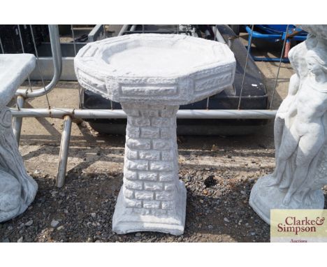 A bird bath with a basin in the form of bricks