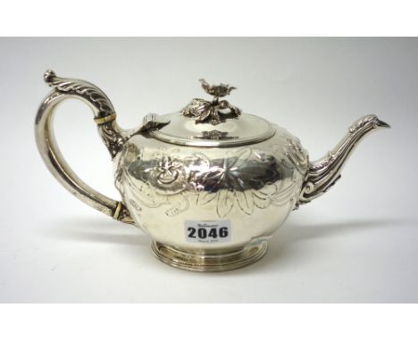 A William IV silver teapot, of squat circular form, later embossed with floral and foliate decoration and with a flower finia