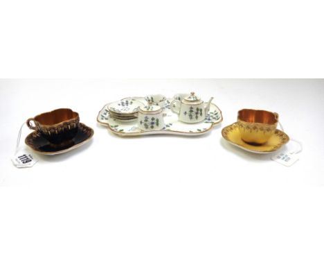 Two Coalport miniature gilt cabinet cups of quadralobe form, circa 1900, one blue and the other yellow, with green printed ma