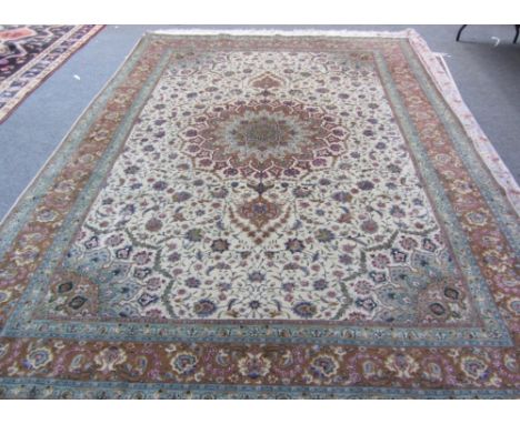 A part silk Tabriz carpet, Persian, the beige field with a rosette pole medallion, matching spandrels, all with delicate flor