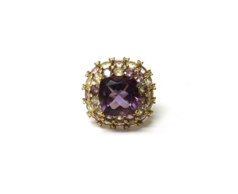 A gold, amethyst, diamond and vary coloured gemstone set cluster ring by Kiki McDonough, claw set with the principal cushion 