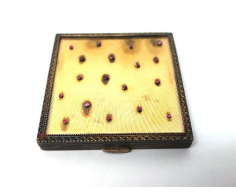 A lady's silver and gilt and cabochon ruby set square powder compact, the top mounted with cabochon rubies, in an abstract de