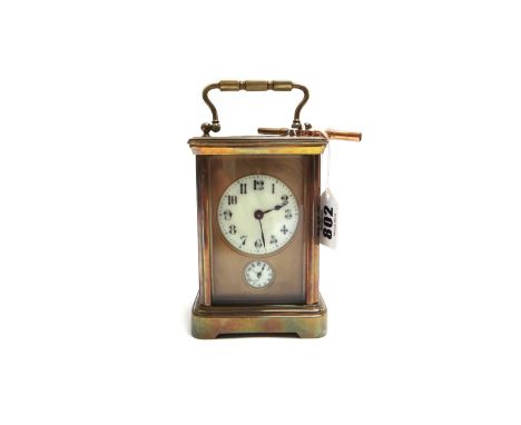 An Edwardian gilt brass cased carriage clock, with enamel dial and subsidiary alarm dial, on a plinth base, with single train