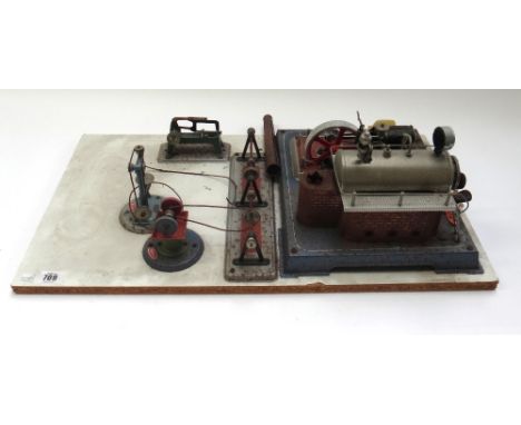 A Wilesco steam engine and fly wheel, board mounted and with grinding stone, pillar drill and chop saw.