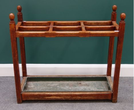 A Victorian oak four division stick stand, with ball finials and chamfered square supports, 92cm wide.