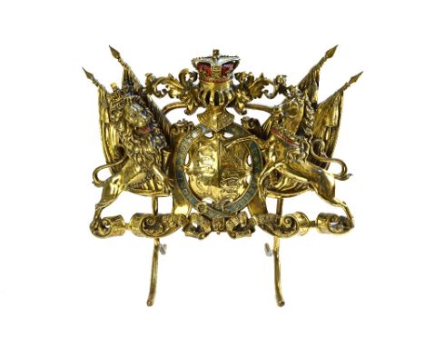 An English gilt brass fire screen, late 19th/early 20th century, modelled and cast as the royal coat of arms, on a shaped met