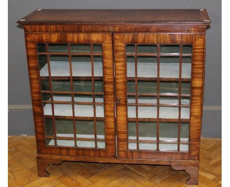 A 19th century mahogany bookcase, the crossbanded rectangular top over a pair of glazed barred doors enclosing two shelves on