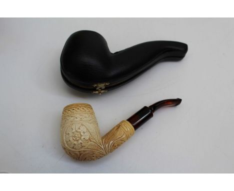 A Meerschaum pipe, the bowl carved with flowerheads and geometric bands to an amberoid stem, 14cm, cased