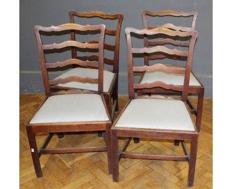 A set of four early 19th century mahogany wavy ladder back dining chairs, each with drop in seat on inner chamfered square fo