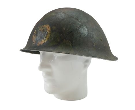 A British Army Mk III helmet bearing a camouflage paint finish with unit insignia, (liner lacking)