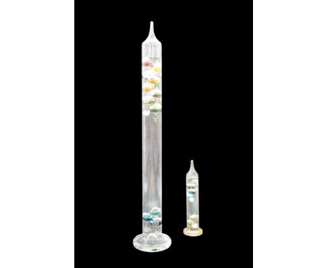 A large glass Galileo thermometer together with a smaller example, former 62 cm
