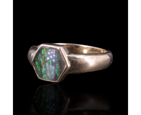 An ammolite ring, comprising a shallow hexagonal cabochon bezel-set on a heavy tapering on a tapering 14 ct gold shank, R, 5.