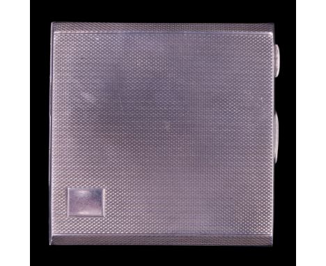 A 1945 silver powder compact, decorated overall with fine engine turning and bearing a small vacant cartouche, 7 cm, 87 g