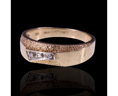 A 1960s - 1970s diamond ring, the tapering band faced with an asymmetric plaque set with three small graded diamonds and part