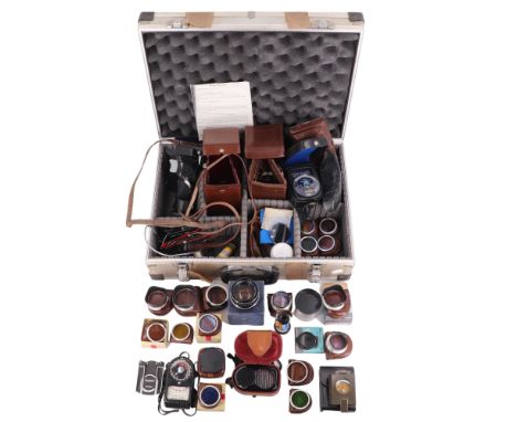 A group of vintage Rollei and other camera accessories including a hard-shell travel case, light meters and lens hoods, case 