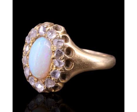 A late Victorian / Belle epoque opal and diamond ring, comprising an oval opal cabochon framed by gallery-set rose cut diamon