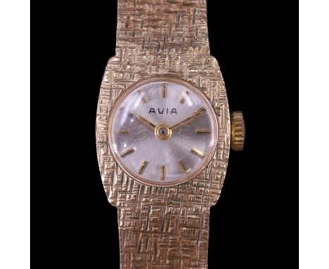 A lady's 1977 Avia 9 ct gold dress wristwatch, having a textured tonneau-shaped case and conforming flexible bracelet strap, 