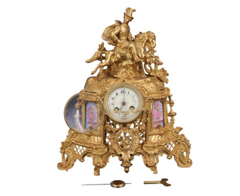 A late 19th / early 20th Century French ormolu mantle clock, adorned with a horse riding scene and Limoges style floral appli