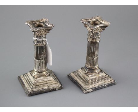 A pair of Edwardian silver corinthian column dwarf candlesticks by Williams Ltd, Birmingham, 1905, height 16.4cm, weighted, a