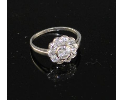 A white metal and eleven stone diamond circular cluster ring, size K, gross weight 3.1 grams. Condition: Central bezel repair