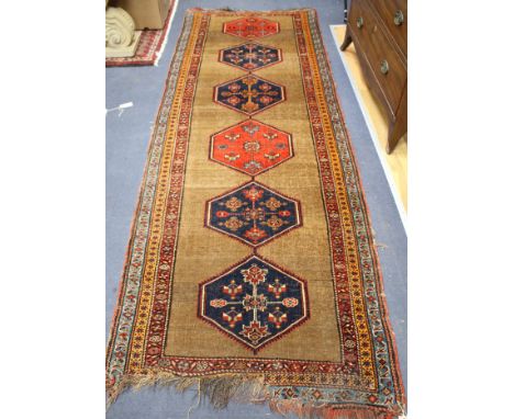 A Caucasian runner, with foliate motif hexagons on a brown ground, multi-bordered, 290 x 98cm Condition: Some light wear to t