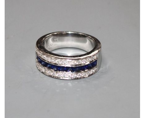 A modern 750 white metal sapphire and diamond set three row half eternity ring, size M, gross 9.2 grams. Condition: Overall c
