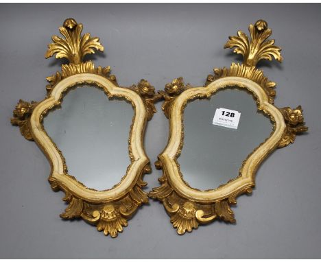 A pair of Italian giltwood cartouche shaped wall mirrors, width 25cm, height 43cm Condition: Some minor wear to the gilding a