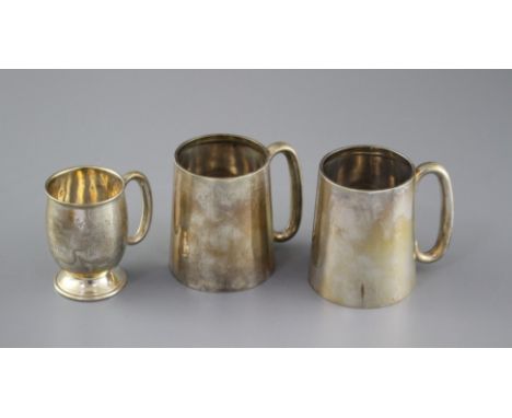 A pair of George V silver mugs, William Hair Haseler, Birmingham, 1935/7, height 85mm and one other smaller silver mug, 12.5o