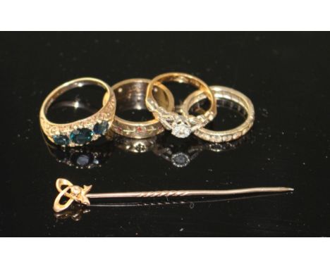 A 1960's 9ct gold and three stone sapphire ring with diamond chip spacers, three other dress rings and a stick pin. Condition