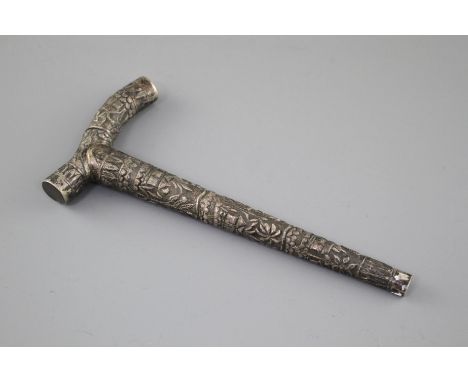 An Indian? embossed white metal cane handle, unmarked, 21.5cm, 2.5oz. Condition: Large dent to edge of handle. Very tarnished