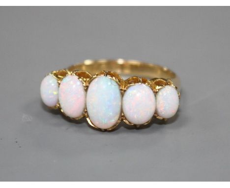 An Edwardian 18ct gold and graduated five stone white opal half hoop ring, size Q, gross 5.5 grams. Condition: Some minor sur