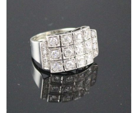 A white metal (stamped 750 and Pt 950) and pave diamond set cocktail ring, of curved design and set with twenty round cut sto