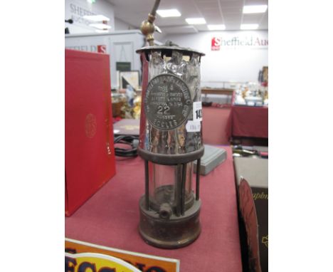 A Miners Lamp by Protector Lamp &amp; Lighting Co, Eccles, 23cm high with handle down.